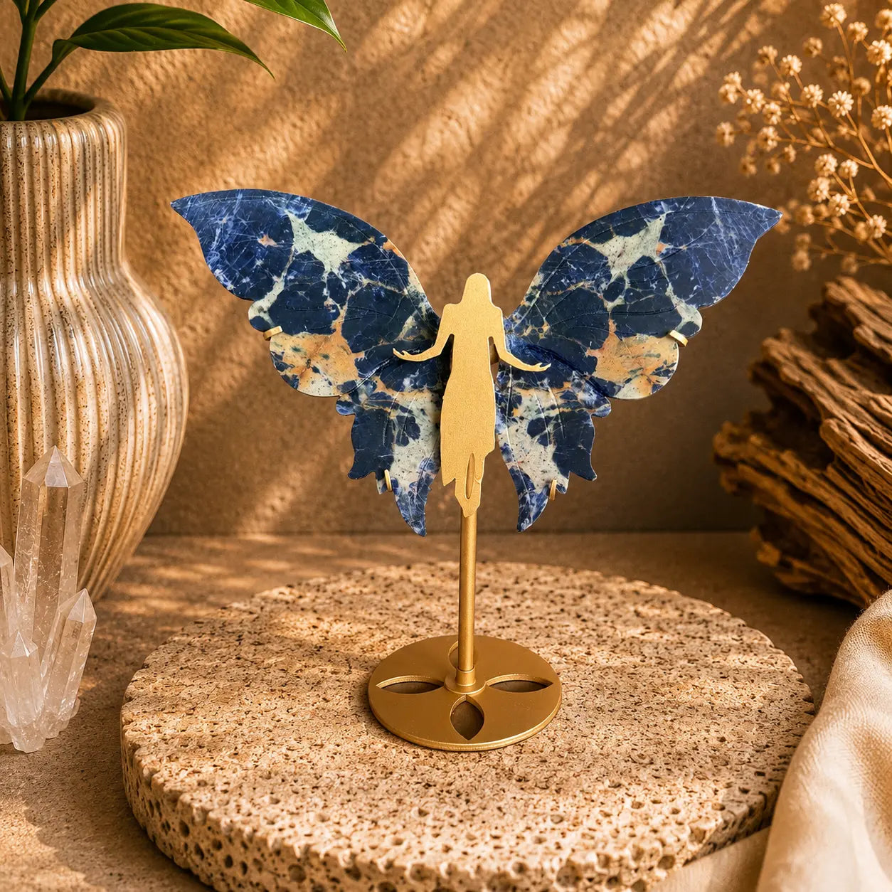 Deep blue Sodalite crystal wings with white veining displayed on a golden angel stand