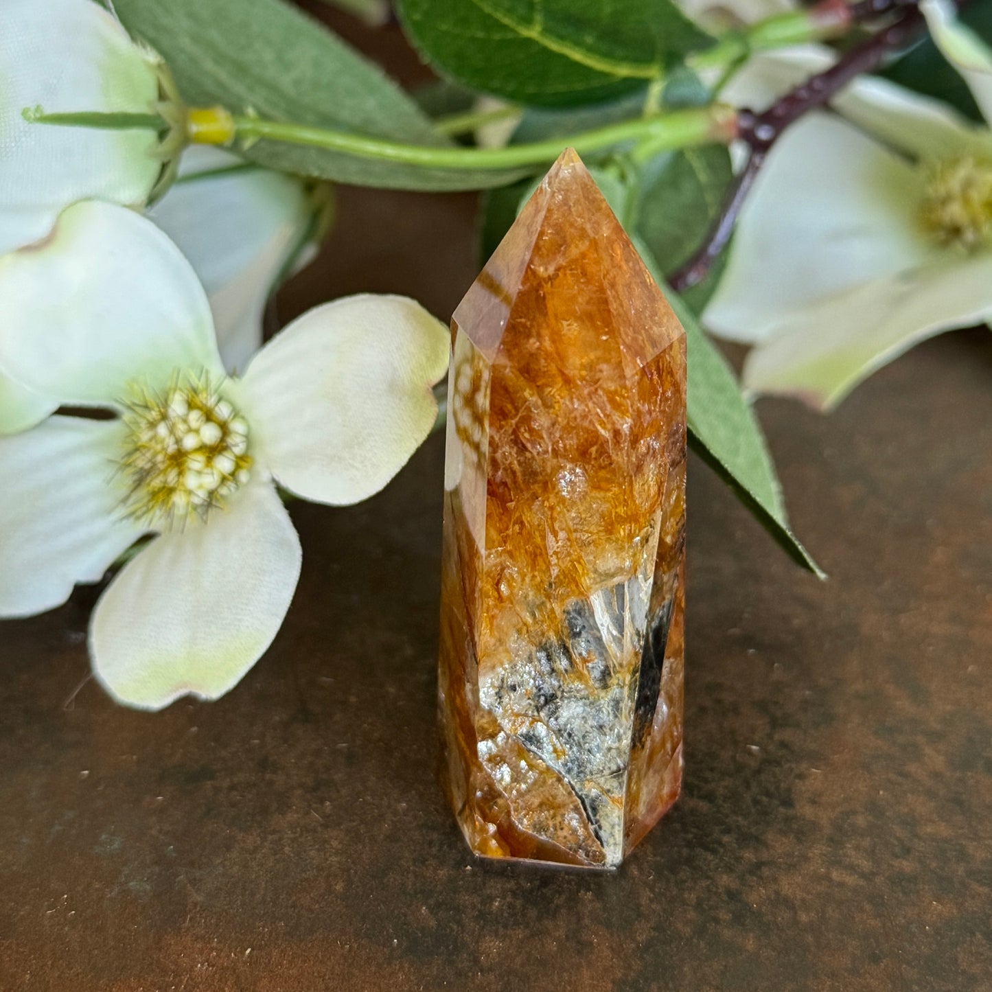 42g · 62mm
Golden Healer Quartz Tower, 42g and 62mm tall, with deep amber-orange colouring and dark mineral inclusions near the base