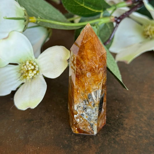 42g · 62mm
Golden Healer Quartz Tower, 42g and 62mm tall, with deep amber-orange colouring and dark mineral inclusions near the base
