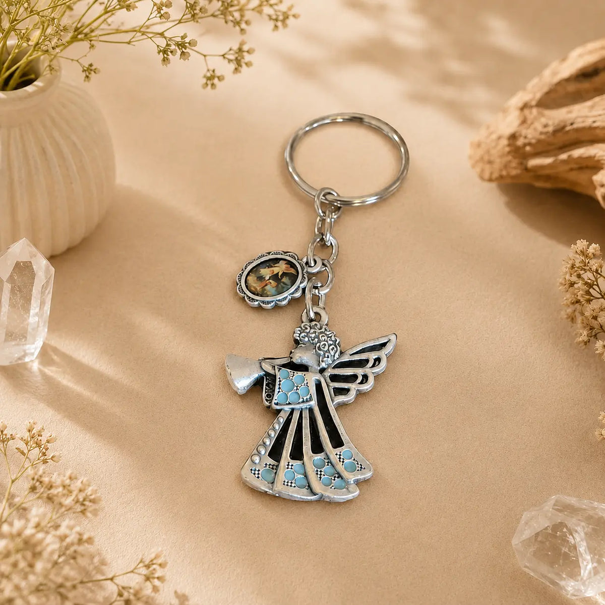 Silver Guardian Angel keyring with turquoise accents on a warm neutral background