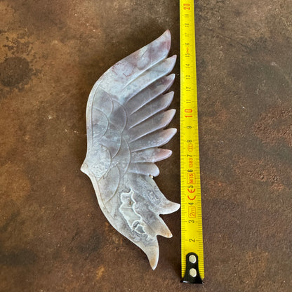 Moss Agate Crystal Wing amd measuring tape for scale on a brown surface