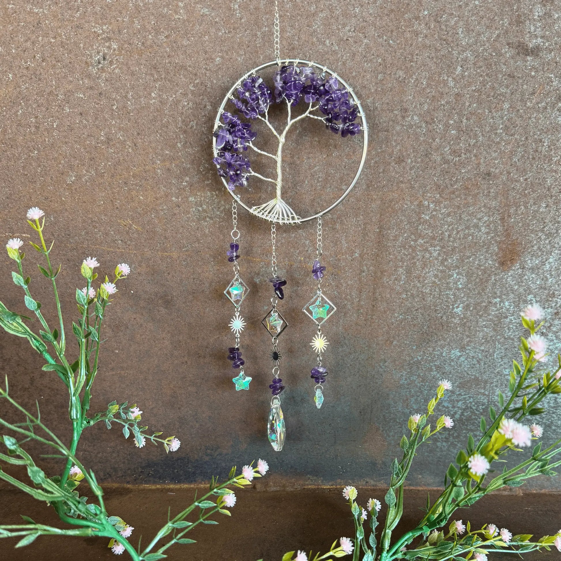 Decorative Tree of Life Crystal Sun Catcher - Amethyst hanging ornament with tree design and blue stones on a textured surface.